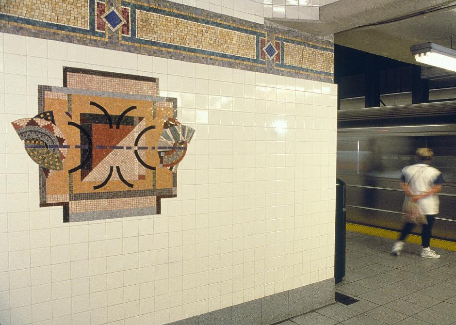 Artwork in marble mosaic on platform walls by Laura Bradley showing abstract shapes.