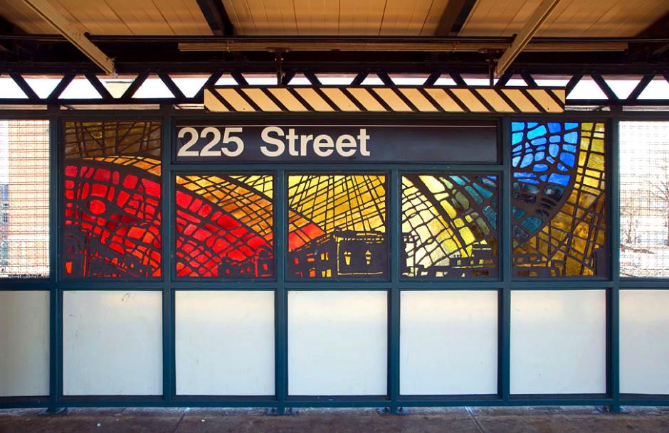 Artwork in faceted glass by Nicky Enright showing cityscapes with vast colorful skies. 