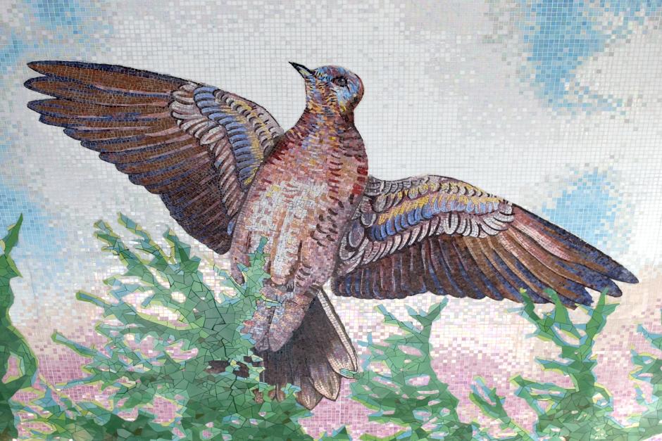 Artwork in ceramic, glass, and marble mosaic by Cadence Giersbach showing a sky with birds and butterflies on the station ceiling.  