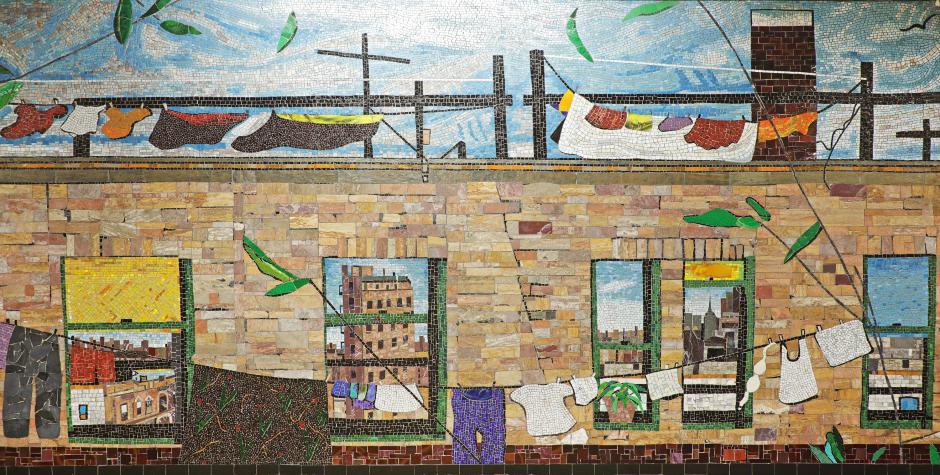 Artwork in glass, stone, and marble mosaic by Frank Leslie Hampton showing windows of an apartment building and a skyline.  