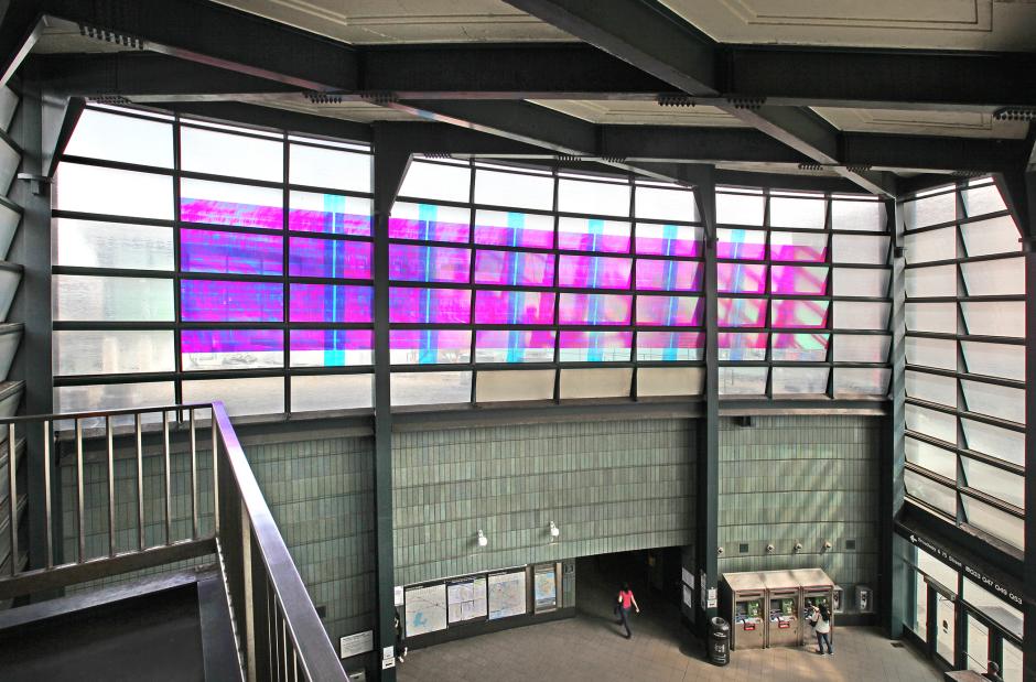 Artwork in laminated colored glass by Tom Patti features trapezoidal-shaped windows fitted into steel layered with a plasma composite material to break up light into the colors of the spectrum. 