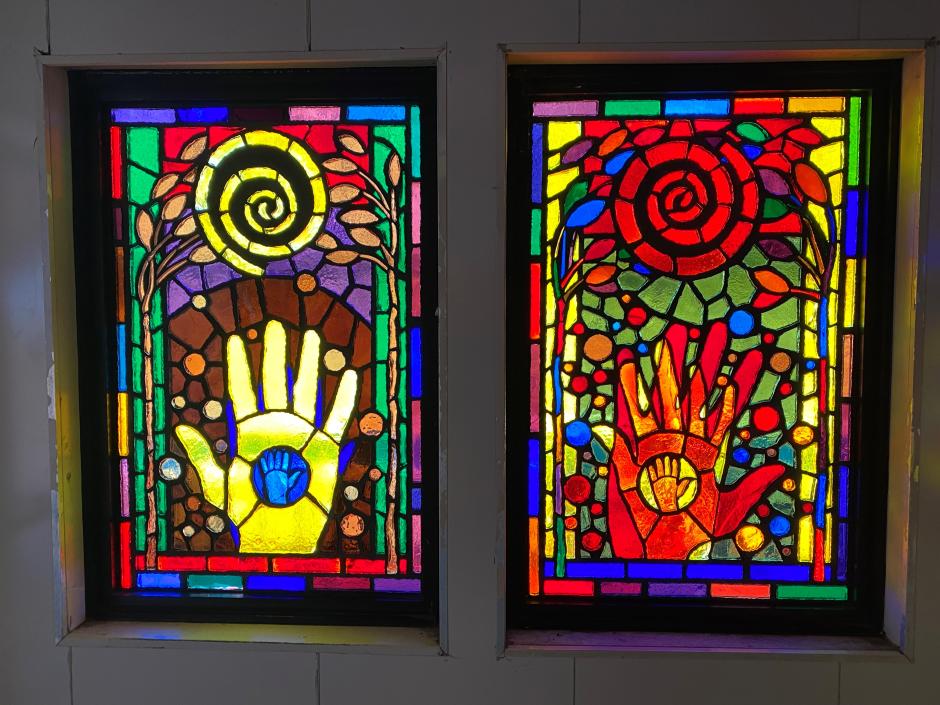 Artwork in faceted glass by Juan Sánchez showing colorful hands with abstract patterns.  