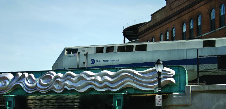 Artwork in aluminum by Barbara Segal showing large reliefs representing flowing water installed on the train overpass. 