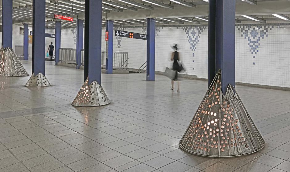 Image depicting metal artwork with small in-set lights wrapping around station columns.