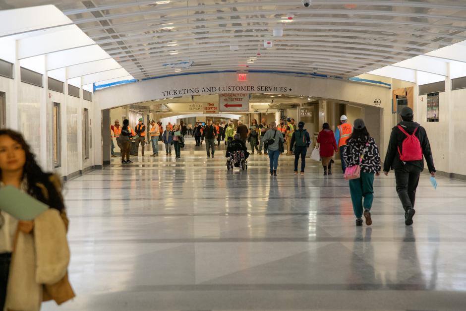 People walk through a hallway in a train station