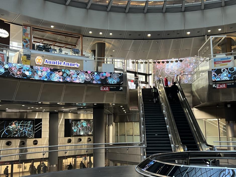 View of Fulton Center with colorful artwork on the digital screens.